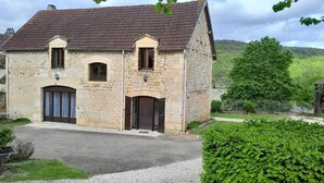 A stone building with a pitched roof, two windows, and a door. - Gîte des Milandes * Vue imprenable sur le Château (Castelnaud-la-Chapelle)