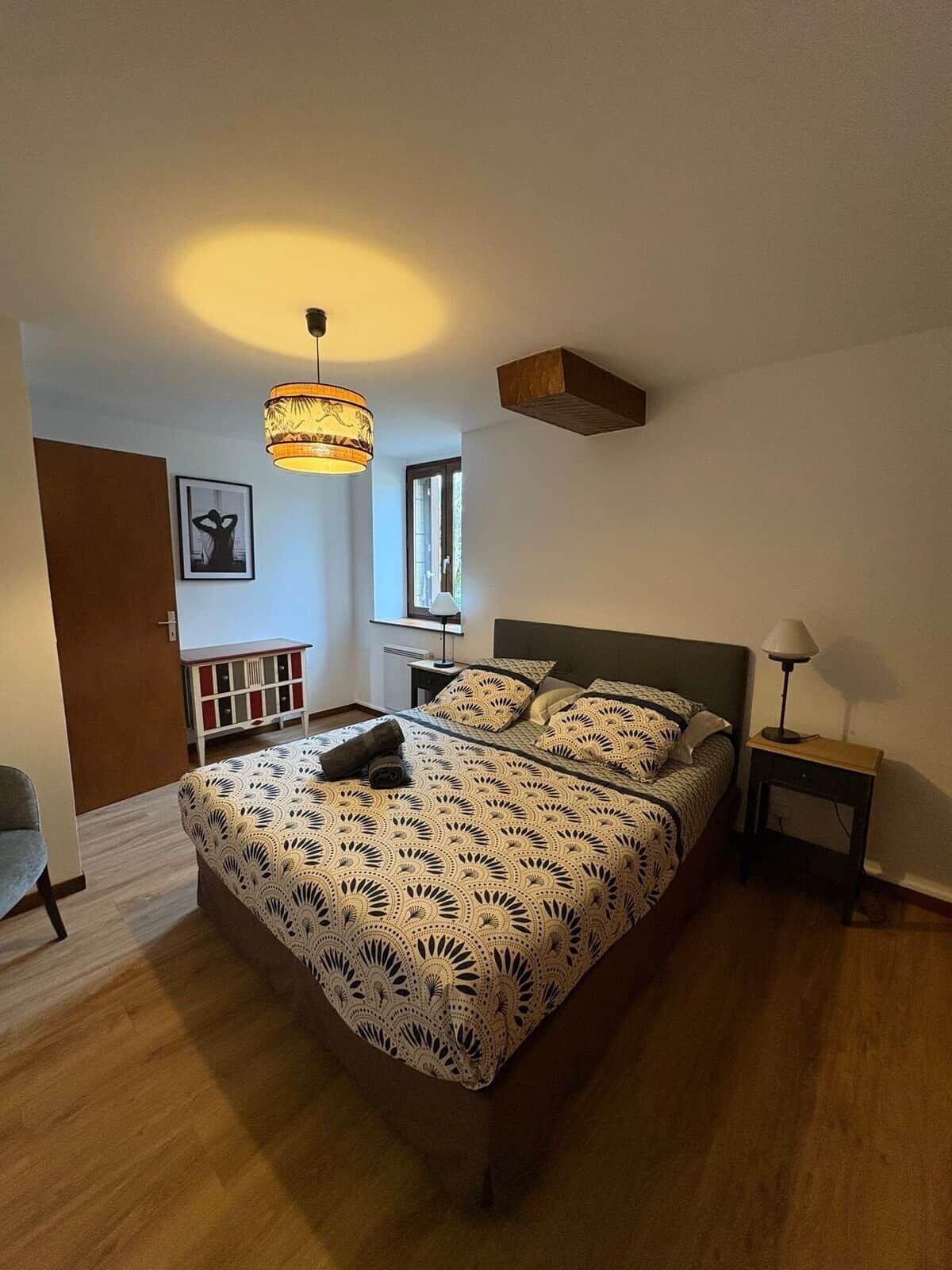 Una camera da letto con un letto, un comodino, una lampada, una finestra e una porta.