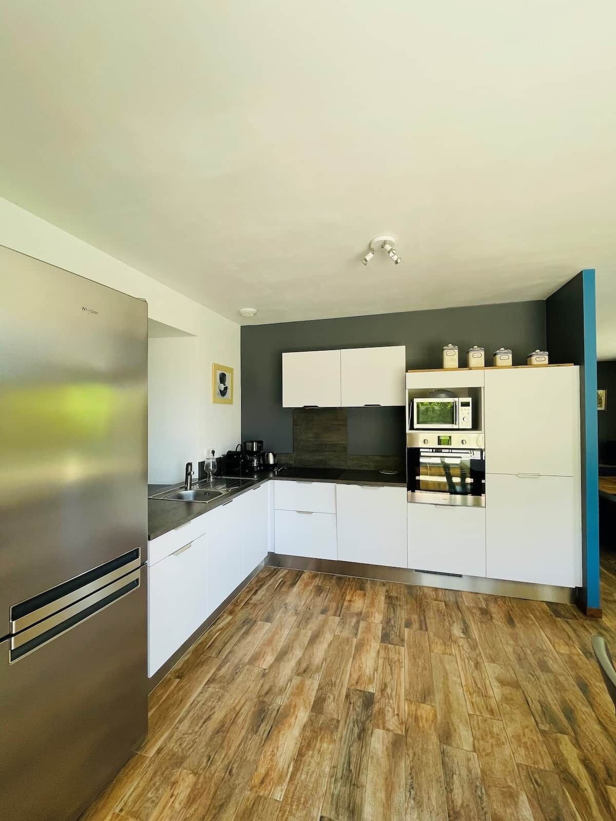 A modern kitchen with a stainless steel refrigerator, a microwave, and a stove.