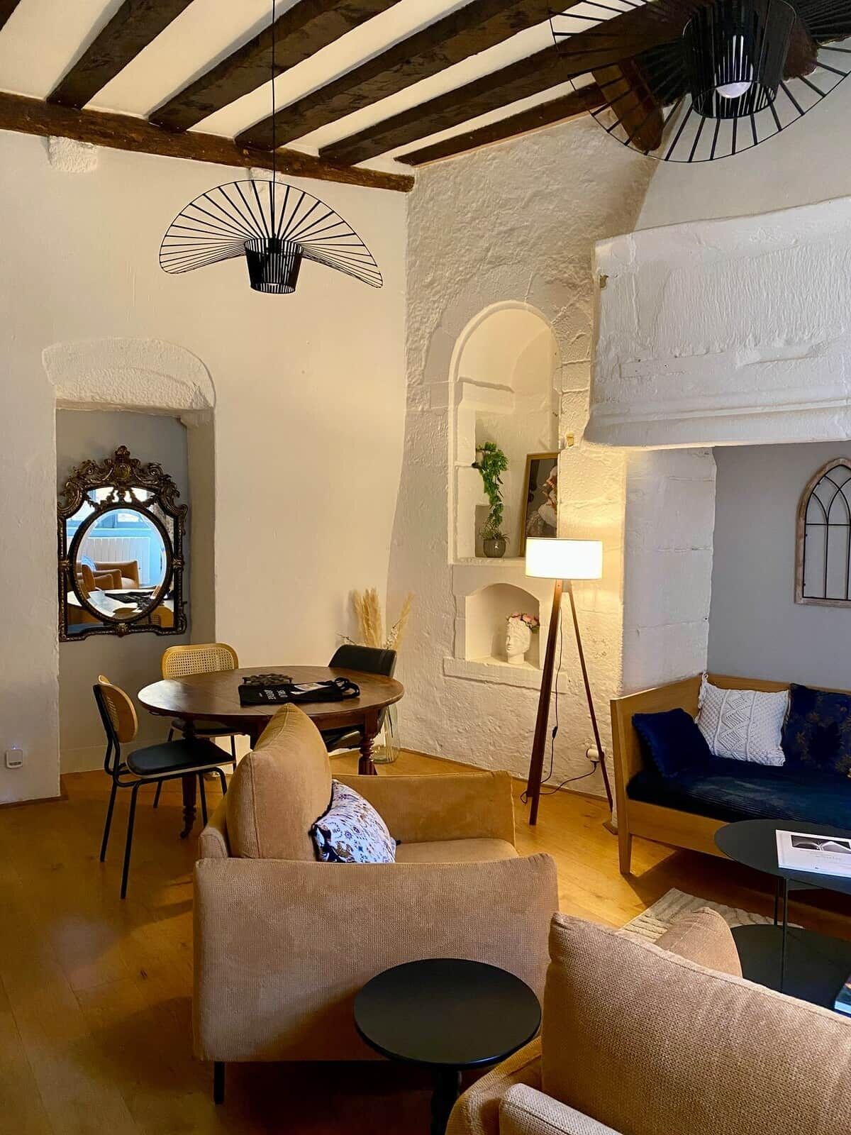 A cozy living room with a dining area, a sofa, a small table, and a lamp.