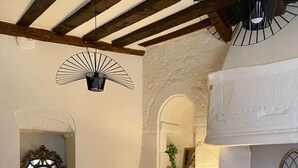 Una sala de estar acogedora con comedor, un sofá, una mesita y una lámpara.