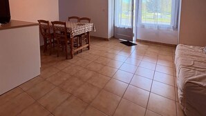 Quarto amplo com área de jantar, cama e uma grande janela com vista para o exterior.
