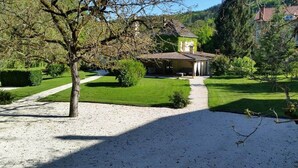 A house with a gravel driveway, a lawn, and a garden with various plants and trees. - Villa 10 pers*Piscine*Daglan (Daglan)