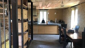 Une cuisine avec des meubles en bois, un îlot central et des luminaires suspendus.