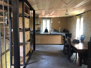 A kitchen with wooden cabinets, a central island, and pendant lighting. - Maison de charme* Piscine chauffée* Bouzic (Bouzic)