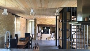 Un intérieur rustique comprenant un coin repas, une cuisine et un escalier.