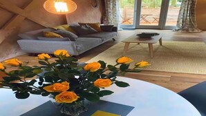 Una sala moderna con un sofá, una mesa de centro y un jarrón de rosas amarillas.