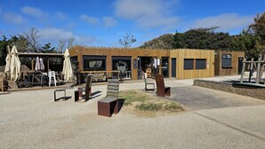 A wooden building with a café, outdoor seating, and a sign reading 'La Place.' - Bocage Residence at the Heart of Bourgenay Golf Course (Talmont-Saint-Hilaire)