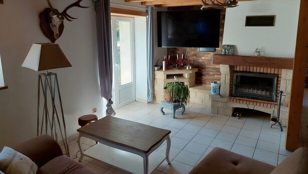 A living room with a fireplace, a television, and a dining table.