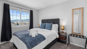 Ein Hotelzimmer mit Bett, Nachttisch, Spiegel und Blick auf die Stadt.