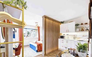Un intérieur moderne comprenant un lit, un coin repas et une cuisine.