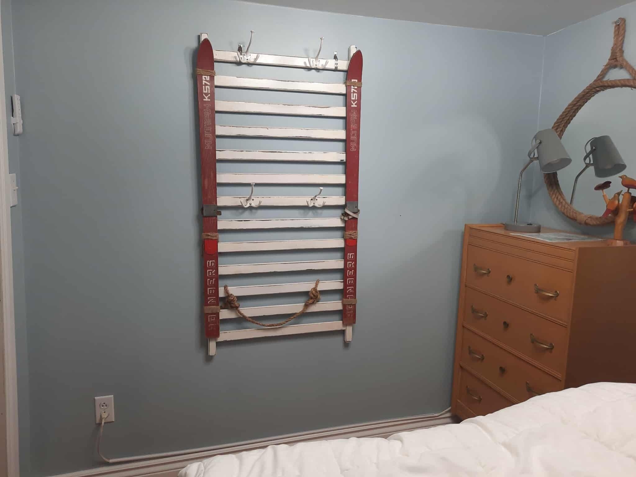 Une pièce comprenant un meuble mural, une commode et un lit.