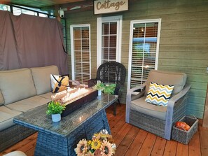 Ein gemütliches Cottage-Interieur mit Sofa, Sessel, Korbstuhl und Kamin.