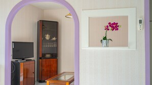 A room with a television, wooden cabinet, and a table with a glass top. - Holiday Home “Quartier Calme” with Private Garden (Royan)