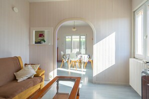 Un salon comprenant un canapé, une table basse et un coin repas avec des chaises et une table.