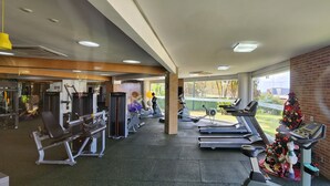 Ein Fitnessstudio mit Laufbändern, Kraftgeräten und einem Weihnachtsbaum.