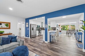 Eine moderne Küche mit weißen Schränken, Edelstahlgeräten und einer blauen Akzentwand.