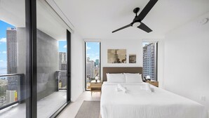 Ein modernes Hotelzimmer mit einem großen Bett, einem Deckenventilator und Blick auf die Stadt.