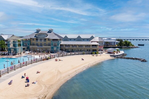 A beachfront hotel with a swimming pool, beach, and ocean view.