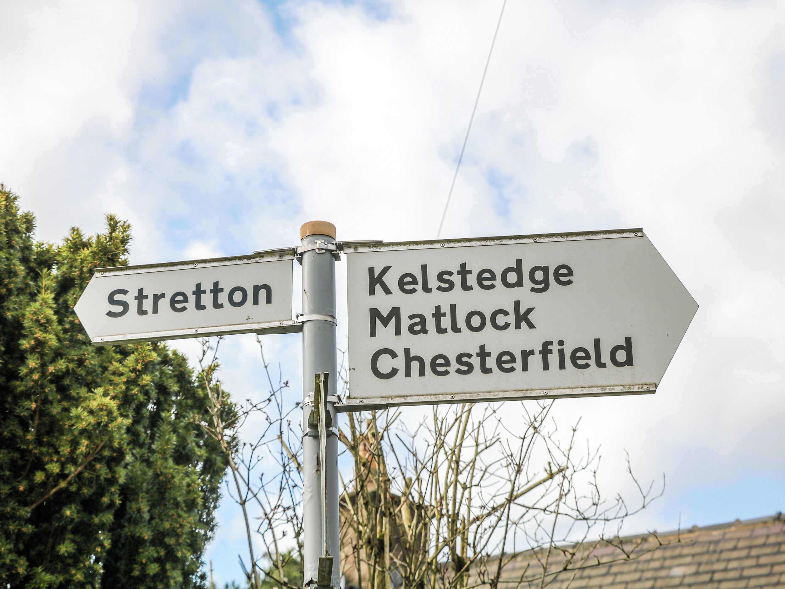 Un panneau indicateur directionnel avec des flèches pointant vers les destinations suivantes : Strelton, Kelstead, Matlock et Chesterfield.