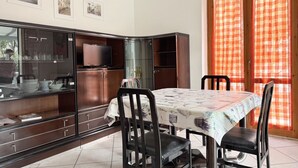 Un'area pranzo con tavolo, sedie e un armadietto con vetrate.