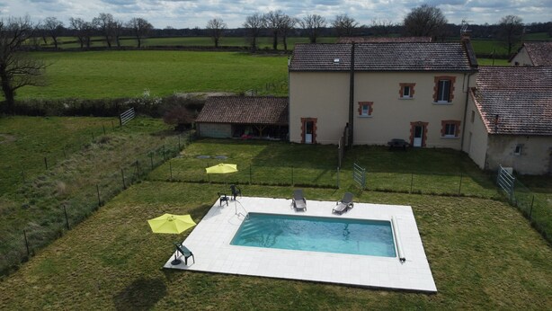 Une maison avec une piscine, un jardin clos et une vue sur la campagne.