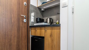 Una cocina compacta con cafetera, hervidor y lavavajillas.
