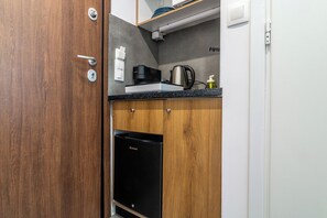 A compact kitchen with a coffee maker, kettle, and a dishwasher. - Modern Studio in Syntagma - Walk to Acropolis (Athina)