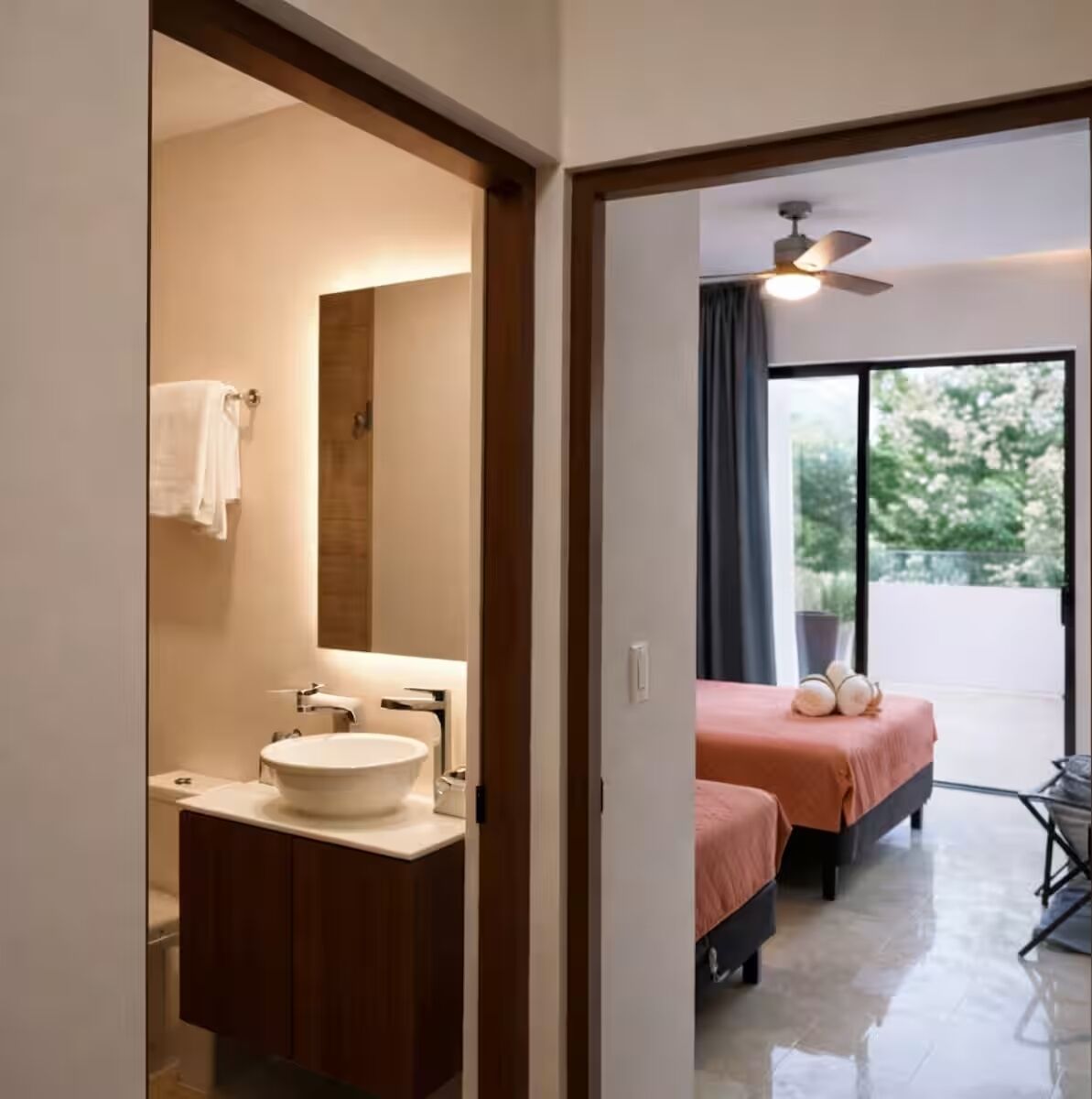 A modern bathroom with a sink, mirror, and towel rack.