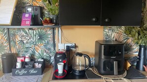 Una cocina con espacio para café, una cafetera Bosch, una cafetera Homaway y un altavoz Polaroid.