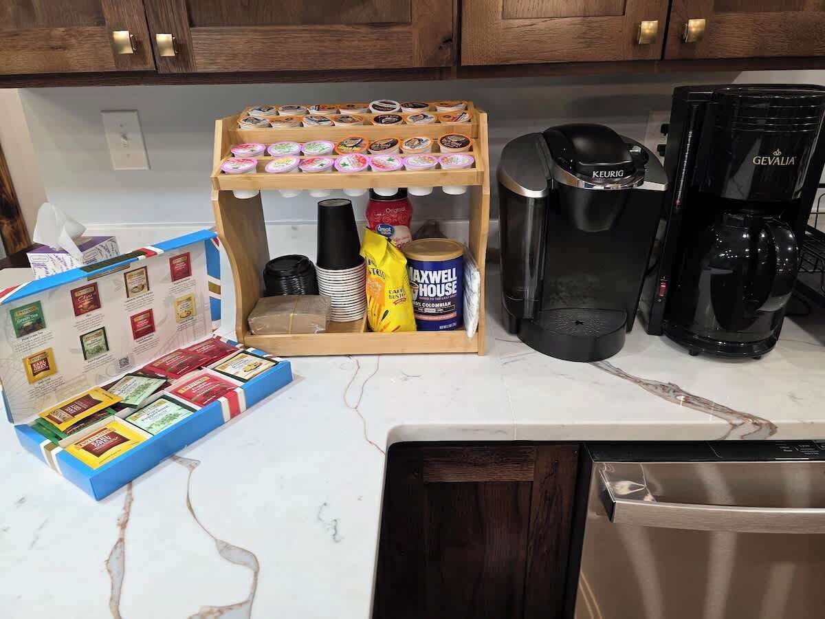Une cuisine équipée d’une machine à café, d’une machine Keurig, d’un distributeur de grains de café et d’une boîte de dosettes de café.