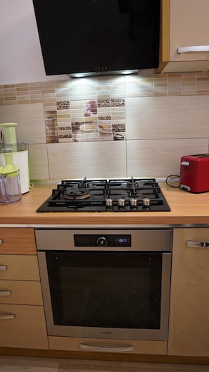 A kitchen with a Bosch blender, a red toaster, and a Whirlpool oven.