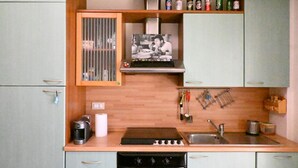 Una cocina compacta con estufa, fregadero y alacenas.
