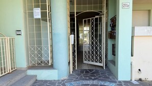 Entrada de un edificio con un cartel que dice 'RESIDENZA LO SCOLLO' y el número '251/a' en la pared.