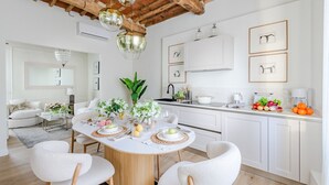 A modern kitchen with white cabinetry, a central island, and pendant lighting.
