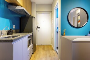 A modern kitchen with a built-in oven, a microwave, and a sink. - StayHome Frei Caneca Rooftop Gym Jacuzzi (São Paulo)