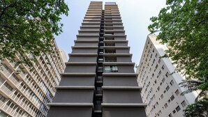 A high-rise building with a central staircase, surrounded by trees. - StayHome Frei Caneca Rooftop Gym Jacuzzi (São Paulo)