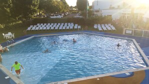 A swimming pool with multiple lanes, a lifeguard stand, and a deck area with lounge chairs.