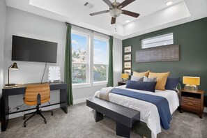 A bedroom with a bed, desk, chair, and a ceiling fan. - Modern EaDo Stay - 3BR Townhome w/ Private Deck (Houston)
