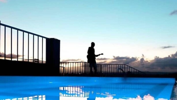 A person standing by a pool with a railing, under a clear sky. - Snowhaven Kiambu rd| Studio Apt - Swimming pool (Nairobi)
