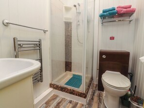 A bathroom with a shower, toilet, and a towel rack with towels. - Number 3 (Blackpool)