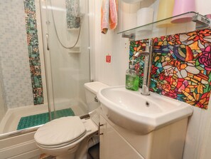 A bathroom with a shower, toilet, sink, and a colorful stained glass window. - Number 2 (Blackpool)