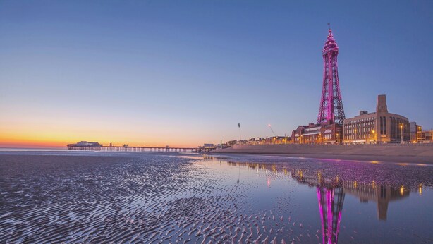 A coastal scene with a prominent tower and a pier extending into the water. - Number 6 (Blackpool)