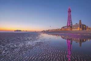 A coastal scene with a prominent tower and a pier extending into the water. - Number 6 (Blackpool)