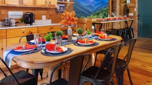 A wooden interior with a dining table set for four, a coffee bar, and a scenic mountain view. - <10 Min to Lake & DT! Flat Drive! Hot Tub! Games! (Blue Ridge)