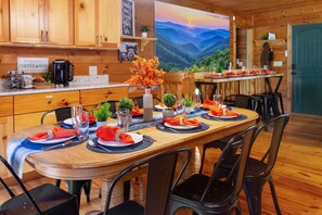 A wooden interior with a dining table set for four, a coffee bar, and a scenic mountain view. - <10 Min to Lake & DT! Flat Drive! Hot Tub! Games! (Blue Ridge)