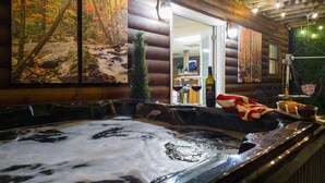 A hot tub with a wooden exterior, a small tree, and a bottle of wine on a table. - <10 Min to Lake & DT! Flat Drive! Hot Tub! Games! (Blue Ridge)
