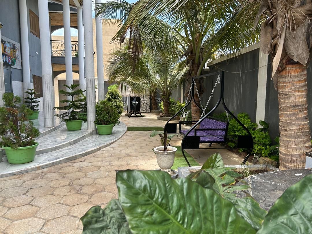 Un patio con palmeras, una hamaca y una zona de estar.