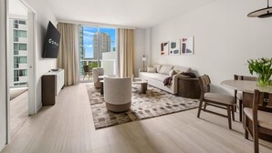 Een moderne woonkamer met een bank, fauteuils, een salontafel en een eethoek met stoelen.