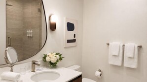 Een moderne badkamer met een wastafel, spiegel en toilet.